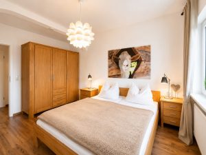 Doppelbett und Kleiderschrank im Alpinpartment 12
