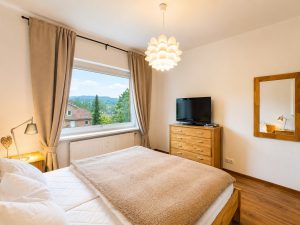 Schlafzimmer mit Fensterblick im Alpinpartment 12